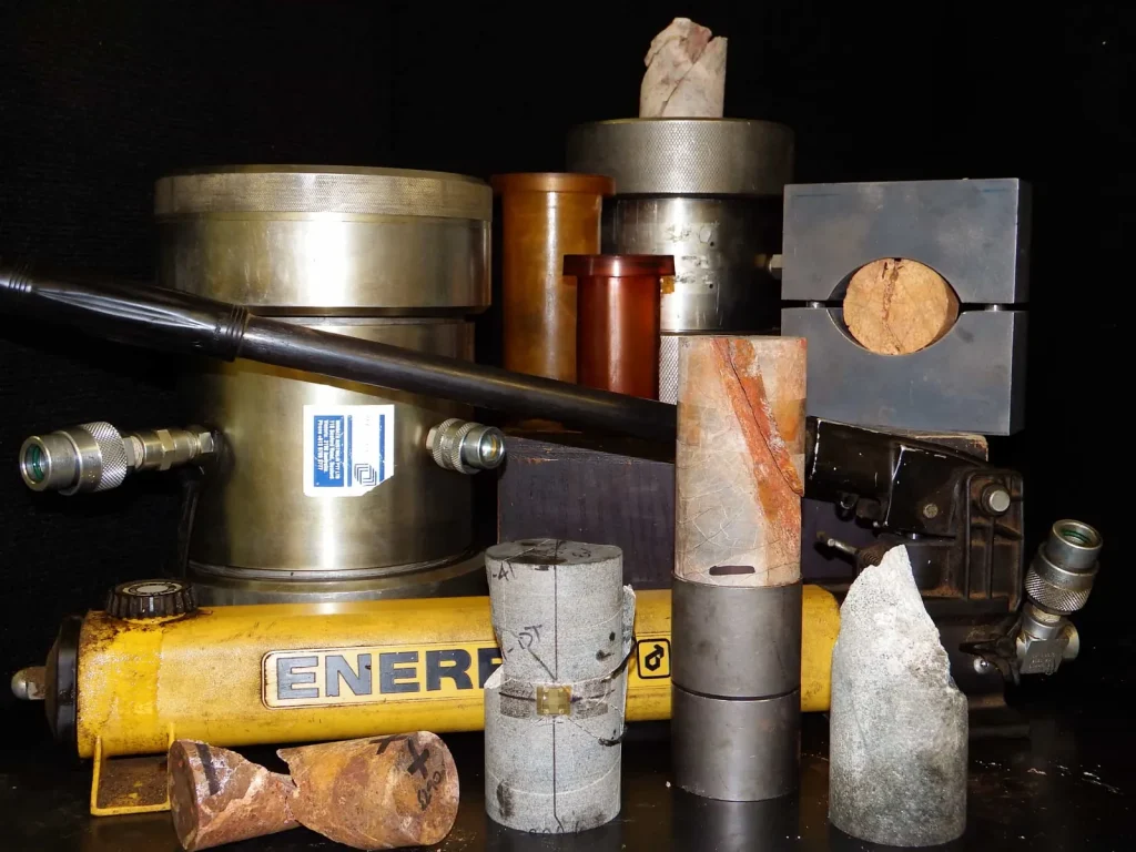 Rock core samples beside a compression testing frame