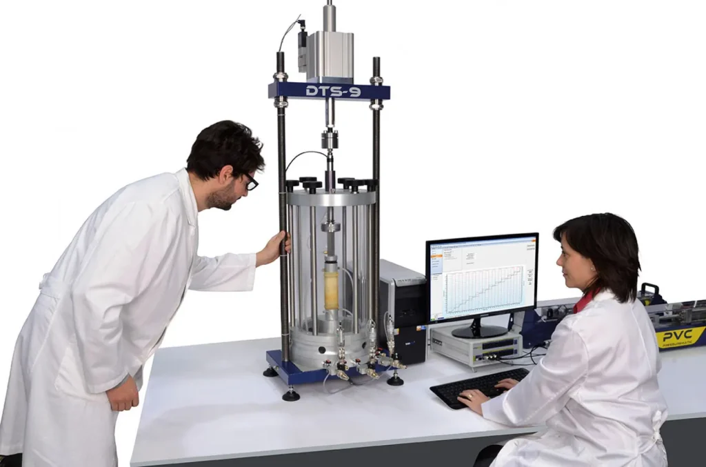 Scientists running a triaxial soil test in a geotechnical laboratory